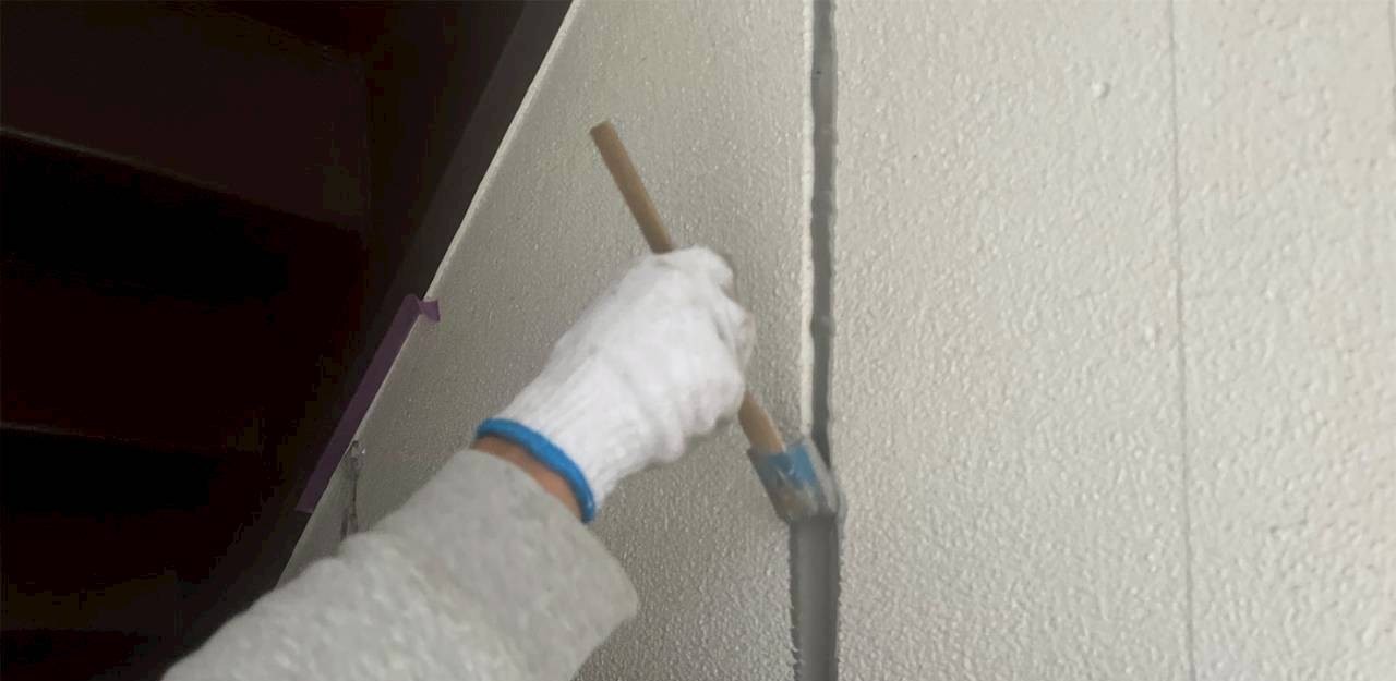 外壁のシーリングならし作業(刷毛で整える様子)